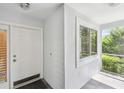 A bright entryway featuring a white front door, tiled flooring, and a view of the screened-in porch at 13636 Lake Point S Dr, Clearwater, FL 33762