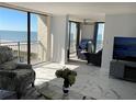 Bright living room features stylish furniture and a stunning ocean view from the private balcony at 1380 Gulf Blvd # 805, Clearwater, FL 33767