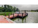 A red, wooden dock extends into a lake, ideal for boating and enjoying the serene water views at 1407 Brattleboro Cir, Sun City Center, FL 33573