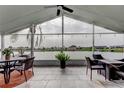 Enclosed lanai featuring a ceiling fan, tiled floor, and views of the water at 1407 Brattleboro Cir, Sun City Center, FL 33573