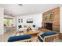 Staged living room with a stone fireplace, neutral furniture, and large windows at 152 58Th S Ave, St Petersburg, FL 33705