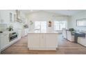 Bright and spacious kitchen featuring white cabinetry, stainless steel appliances, and a large center island at 16106 Worlington Pl, Odessa, FL 33556