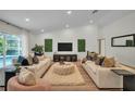 Open-concept living room boasts vaulted ceilings, recessed lighting, and sliding glass doors to the pool area at 16106 Worlington Pl, Odessa, FL 33556