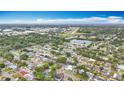 Aerial view of a neighborhood with lush greenery, a pond and an airport runway at 1737 Prince Philip St, Clearwater, FL 33755