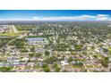 Wide aerial view showcasing a verdant neighborhood with a pond and an airport in the background at 1737 Prince Philip St, Clearwater, FL 33755
