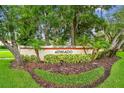El Pasado community sign surrounded by vibrant landscaping and mature trees at 1801 E Lake Rd # 20 G, Palm Harbor, FL 34685