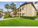 Well-maintained condo building featuring lush lawn, mature trees, and ample outdoor space at 1801 E Lake Rd # 20 G, Palm Harbor, FL 34685