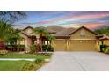 Charming single-story home with a tile roof, lush landscaping, and a spacious three-car garage at 20023 Pergola Bend Ln, Tampa, FL 33647