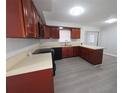 Well-lit kitchen with wood cabinets, black appliances, and light countertops at 2045 Summit Dr, Dunedin, FL 34698
