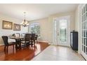 Elegant dining room featuring a wood table, chandelier lighting, and ample natural light at 27209 Firebush Dr, Wesley Chapel, FL 33544