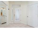 Bright foyer with tile flooring, a white door, and a view of the downstairs half-bath and stairs at 2876 Bayshore Trails Dr, Tampa, FL 33611