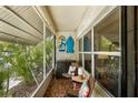 Charming screened porch with tile flooring, comfortable seating, and decorative wall art at 4154 56Th N St # 720, Kenneth City, FL 33709
