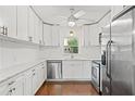 Bright kitchen featuring white cabinets, stainless steel appliances, marble countertops, and hardwood floors at 4309 W Empedrado St, Tampa, FL 33629