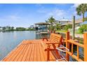 Scenic view of a private dock with a boat lift, bench seating, and tranquil waterfront surroundings at 4523 Gulfstream Dr, Hernando Beach, FL 34607