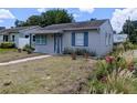 Well-maintained single-story home with blue trim and a well manicured lawn in a neighborhood setting at 5048 5Th S Ave, St Petersburg, FL 33707