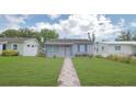 Inviting single-story home features a lush lawn and pathway to the entrance at 5048 5Th S Ave, St Petersburg, FL 33707