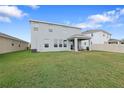 Back view of gray home shows large backyard and covered patio at 5214 Granite Dust Pl, Palmetto, FL 34221