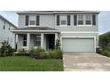Two-story home with gray exterior, dark shutters, manicured lawn, covered front porch and attached two-car garage at 5214 Granite Dust Pl, Palmetto, FL 34221