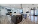 Open concept kitchen featuring a large island with cooktop and stainless steel appliances at 5509 Bluejay Ln, Tampa, FL 33625