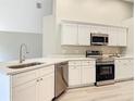 This kitchen features sleek stainless steel appliances, granite countertops, and bright white cabinets at 5809 Silas Creek Ln, Wesley Chapel, FL 33545
