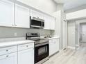 Modern kitchen with stainless steel appliances, white cabinets and granite countertops, offers lots of storage at 5809 Silas Creek Ln, Wesley Chapel, FL 33545