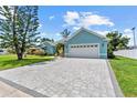 Exterior showcasing a light blue home with a spacious driveway and an attached two-car garage at 716 Laurel Ave, Venice, FL 34285