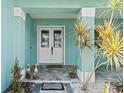 Inviting front porch with double doors, tiled flooring, and tropical plants in decorative white rock at 716 Laurel Ave, Venice, FL 34285