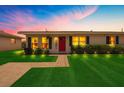 Charming home featuring a manicured lawn and beautiful landscaping with a red door entrance at 8339 75Th Ave, Seminole, FL 33777