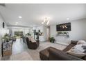 Open-concept living room with hardwood floors, modern lighting, and a comfortable brown leather sectional sofa at 8339 75Th Ave, Seminole, FL 33777