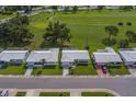 Aerial view of well-maintained single-story homes next to a lush green golf course under a sunny sky, showcasing community at 10005 41St N St, Pinellas Park, FL 33782