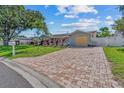 Paver driveway leads to a well-maintained home with mature landscaping and a fenced yard at 10339 111Th St, Largo, FL 33778