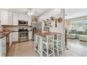 Well-lit kitchen features white cabinets, stainless steel appliances, and center island at 11775 84Th Ave, Seminole, FL 33772