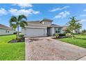 Attractive single-Gathering home with a well-manicured lawn, mature landscaping, and a brick driveway at 11785 Little River Way, Parrish, FL 34219
