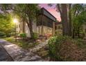 Charming condo featuring a screened lanai, mature trees, and lush landscaping in evening light at 11809 Raintree Lake Ln # A, Tampa, FL 33617