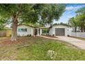 Single story home boasts a fresh exterior, manicured lawn, and a driveway leading to an attached garage at 1349 Tyrone N Blvd, St Petersburg, FL 33710