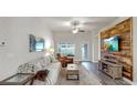 Bright living room featuring stylish furniture, wood-look floors and unique accent wall at 14224 Edinburgh Moor Dr, Wimauma, FL 33598