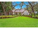 Charming single-story home with well-manicured lawn, lush landscaping, and mature trees at 17802 Mission Oak Dr, Lithia, FL 33547