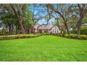 Charming single-story home with well-manicured lawn, lush landscaping, and mature trees at 17802 Mission Oak Dr, Lithia, FL 33547