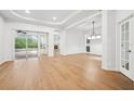 Open-concept living room with wood floors, white walls, and access to the outdoor patio and pool at 17802 Mission Oak Dr, Lithia, FL 33547