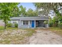 Quaint single-story home with a bright blue front door and convenient carport at 2204 E Idlewild Ave, Tampa, FL 33610