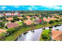 Aerial view of homes with screened lanais, water view, and lush greenery at 2527 Terracina Dr, Venice, FL 34292