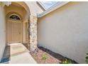 Welcoming front entrance with stone pillar detail and tiled walkway leading to the front door at 2609 Rosehaven Dr, Wesley Chapel, FL 33544