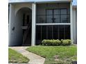 Condo exterior featuring a stairway leading to units, complemented by green grass and manicured shrubs at 2699 Pine Ridge E Way # H2, Palm Harbor, FL 34684