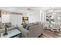 Comfortable living room adjacent to dining area, featuring a plush grey sofa and modern decor at 2699 Pine Ridge E Way # H2, Palm Harbor, FL 34684