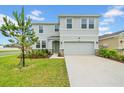 Charming two-story home with stone accents, a two-car garage and landscaped front yard at 32136 Conchshell Sail St, Wesley Chapel, FL 33545