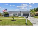 Lovely single-story home with manicured lawn and an American flag at 325 Gladstone Blvd, Englewood, FL 34223