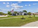Quaint single-story home featuring a well-kept lawn, palm trees, and an American flag at 325 Gladstone Blvd, Englewood, FL 34223