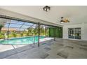 Enclosed pool area with a tiled deck and lush landscaping, perfect for relaxation at 325 Gladstone Blvd, Englewood, FL 34223