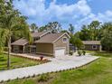 Aerial view features a long driveway, lawn, and detached garage with a screened in porch at 4044 Red Fox Ct, Wesley Chapel, FL 33543
