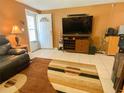Cozy living room featuring a TV, modern tile flooring, and an open doorway at 4214 Trucious Pl # 4212, New Port Richey, FL 34652